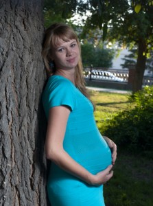 Beautiful pregnant woman relaxing on a park